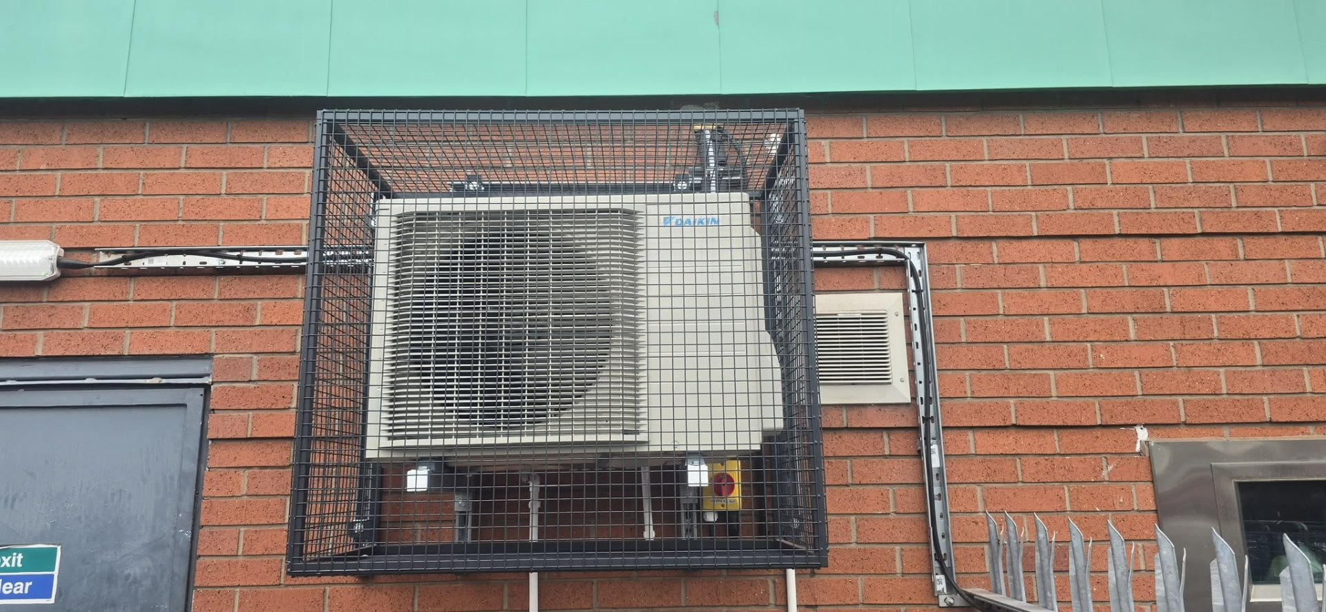 Daikin outdoor condenser unit cleanly installed and pipework lagged in white trunking, North West.