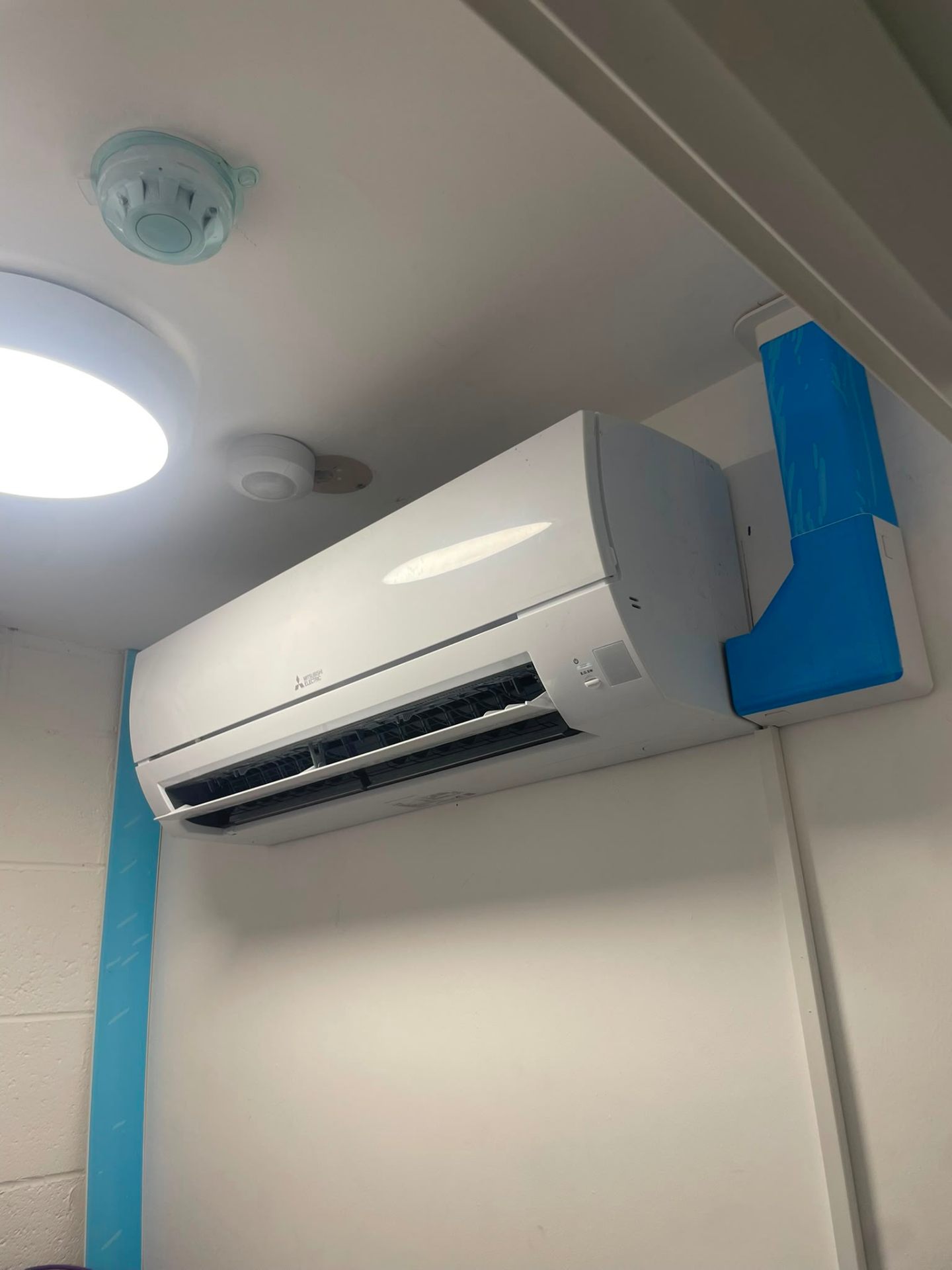 Recently installed Mitsubishi Electric wall-mounted air conditioning unit in a clean commercial interior by JC Heating and Cooling.